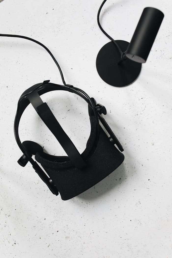 Black VR headset and sensor on white table. Modern tech for immersive experiences.